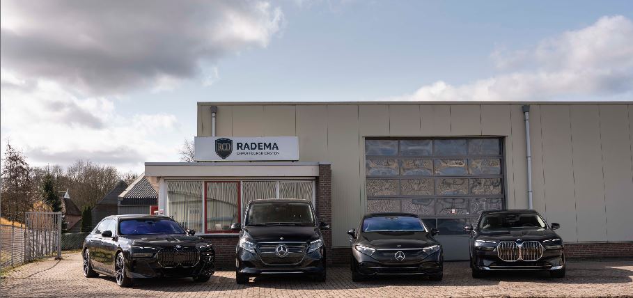 Vier zwarte luxe auto’s (BMW en Mercedes) geparkeerd voor het Radema-gebouw met bord “Radema Gecertificeerd Chauffeursdiensten”, onder deels bewolkte lucht.