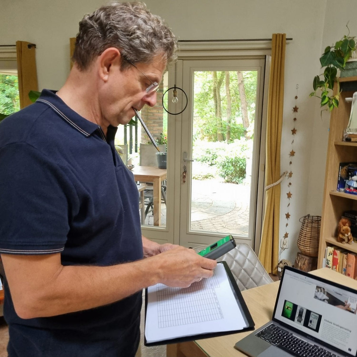 Erik noteert informatie. Sfeerfoto bij Memon-advies of meting van elektromagnetische velden. Man schrijft aantekeningen, grote liggende of staande foto.