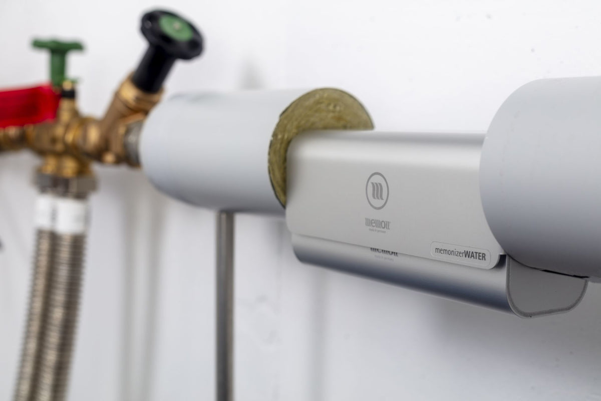 Memon Water Vitalizer gemonteerd op de waterleiding. Watervitalisatie volgens het principe van Masaru Emoto: zuiver, vitaal water zonder schadelijke frequenties. Installatiefoto van het Memon-waterapparaat.