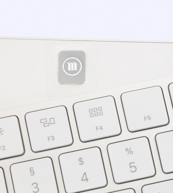 MemonizerWIRELESS-sticker met logo, bevestigd op een wit toetsenbord boven de functietoetsen.